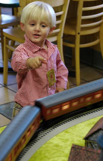 child pointing at a model train