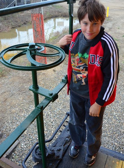 child standing by railroad brake handle