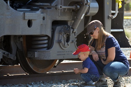 mother and young son looking at locomotive trucks