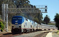 Amtrak train passing under signal bridge